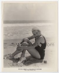 1b346 WYNNE GIBSON 8x10 movie still '20s sitting in sexy bathing suit on sandy beach by the ocean!