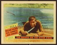 6d199 BRIDGE ON THE RIVER KWAI LC #6 '58 close up of William Holden holding knife on beach!