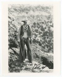 7c303 SAM ELLIOTT signed 8x10 REPRO still '80s full-length in cowboy outfit holding rifle!