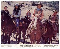 8w067 UNDEFEATED color 8x10 still '69 smiling John Wayne on horseback leading many riders!