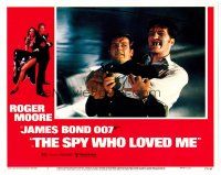 2j758 SPY WHO LOVED ME LC #2 '77 Roger Moore as James Bond squeezed by giant Richard Kiel as Jaws!