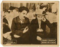 6b488 BEHIND THE SCREEN LC R22 close up of Charlie Chaplin with pipe sitting by Edna Purviance!