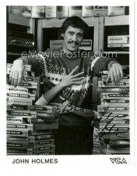 4t641 JOHN HOLMES signed 8x10 REPRO still '90s w/ arms wrapped around him surrounded by videos!
