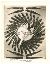 9y129 BETTY GRABLE 8x10.25 still '42 overhead portrait surrounded by rifles from Footlight Serenade!