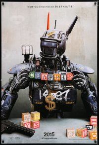 5z174 CHAPPIE teaser DS 1sh '15 close up image of the robot with toy blocks, huge necklace and gun!