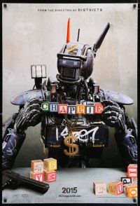 6k111 CHAPPIE teaser DS 1sh '15 close up image of the robot with toy blocks, huge necklace and gun!