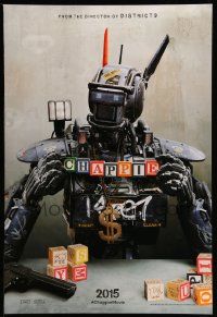 3r324 CHAPPIE teaser DS 1sh '15 close up image of the robot with toy blocks, huge necklace and gun!