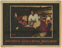 1b106 BLOOD ALLEY signed LC #4 1955 by Lauren Bacall, who's watching John Wayne standing at table!