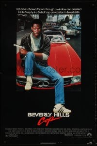 3z539 BEVERLY HILLS COP 1sh 1984 great image of detective Eddie Murphy sitting on red Mercedes!