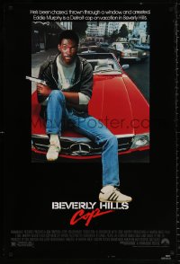 9c512 BEVERLY HILLS COP 1sh 1984 great image of detective Eddie Murphy sitting on red Mercedes!