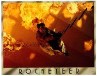 2j676 ROCKETEER LC '91 Disney, cool image of Bill Campbell on ladder over blazing inferno!