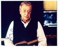 3a331 MICHAEL CAINE signed color 8x10 REPRO still '00s close up of the actor reading a book!