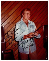 3z436 GEORGE MONTGOMERY signed color 8x10 publicity still '86 in street clothes holding gun at show!
