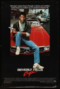 8e072 BEVERLY HILLS COP 1sh '84 great image of cop Eddie Murphy sitting on Mercedes!