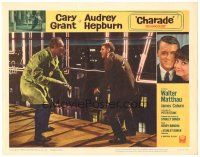 3e267 CHARADE LC #7 '63 close up of tough Cary Grant in fight with George Kennedy on roof!