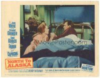 3e669 NORTH TO ALASKA LC #5 '60 close up of Capucine holding John Wayne's hand in bed