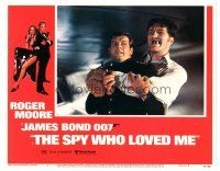 4d853 SPY WHO LOVED ME LC #2 '77 Roger Moore as James Bond squeezed by giant Richard Kiel as Jaws!