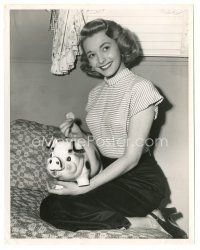 1h732 PATRICIA NEAL 8x10 still '50s putting a Peace silver dollar into her piggy bank!