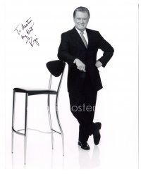 4t722 REGIS PHILBIN signed 8x10 REPRO still '90s standing portrait in suit & tie w/ arm on chair!