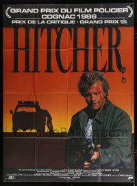 2p671 HITCHER French 1p '86 different image of bloodied Rutger Hauer with machine gun!