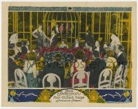 8a071 HER GILDED CAGE LC '22 lots of people at table watch Gloria Swanson by giant bird cage!