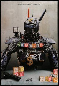 1c151 CHAPPIE teaser DS 1sh '15 close up image of the robot with toy blocks, huge necklace and gun!