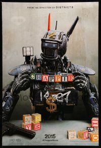 4w166 CHAPPIE teaser DS 1sh '15 close up image of the robot with toy blocks, huge necklace and gun!