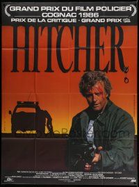 7y449 HITCHER French 1p '86 different image of bloodied Rutger Hauer with machine gun!