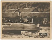 3c440 EYES OF THE FOREST LC '23 great image of cowboy hero Tom Mix leaping onto pile of lumber!