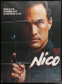 9f603 ABOVE THE LAW French 1p 1988 super close up of cop Steven Seagal with gun, Nico!