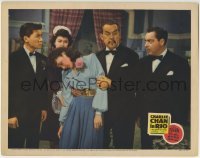 3c368 CHARLIE CHAN IN RIO LC 1941 Victor Sen Yung & others watch Sidney Toler hold fainted woman!