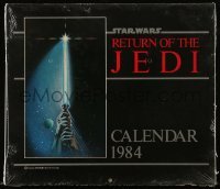 4h056 RETURN OF THE JEDI calendar 11x12 1984 hands holding lightsaber by Tim Reamer on cover!