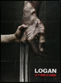 1c740 LOGAN teaser French 1p 2017 super c/u of tiny hand holding Hugh Jackman's Wolverine claw!