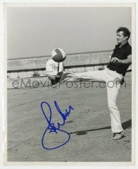 1h502 ROGER MOORE signed 8.25x10 still 1970s the James Bond star kicking a ball in an empty lot!