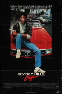 2j117 BEVERLY HILLS COP 1sh 1984 great image of detective Eddie Murphy sitting on red Mercedes!