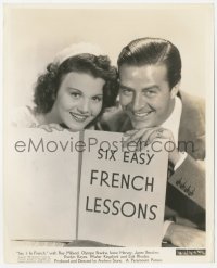 3r0506 SAY IT IN FRENCH 8.25x10 still 1938 happy Ray Milland & Olympe Bradna holding sign!