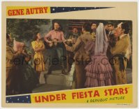 3z1326 UNDER FIESTA STARS LC 1941 cowboy Gene Autry plays his guitar for Carol Hughes & crowd!