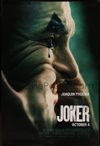 7x0204 JOKER DS bus stop 2019 close-up image of clown Joaquin Phoenix putting on a happy face!