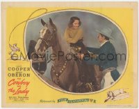 9p1073 COWBOY & THE LADY LC R1944 Gary Cooper helps pretty smiling Merle Oberon on horseback!