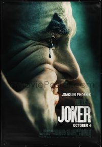 9r0109 JOKER DS bus stop 2019 close-up image of clown Joaquin Phoenix putting on a happy face!