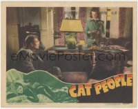 5f0254 CAT PEOPLE LC 1942 Tourneur, Kent Smith on couch looks at sexy Simone Simon behind desk!