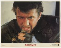 5f0352 MAD MAX 2: THE ROAD WARRIOR int'l LC 1982 super close up of Mel Gibson loading his gun!